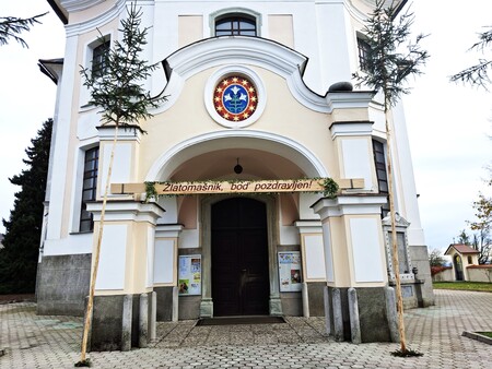 Pred cerkvijo so postavili visok mlaj in tablo z napisom Pozdravljeni zlatomašnik